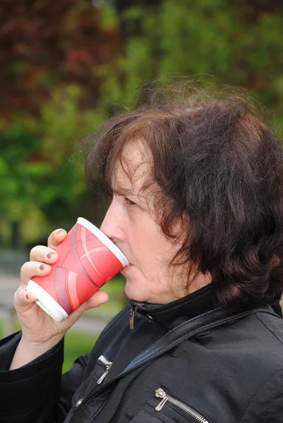 Femme mûre buvant du café dans le parc — Photo