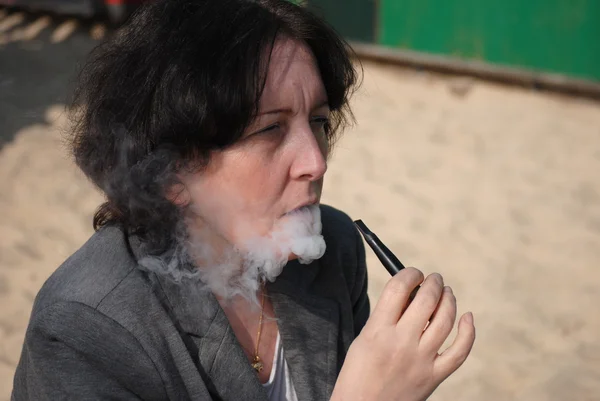 Mature woman smoking electronic cigarette — Stock Photo, Image