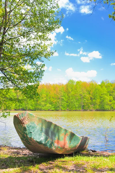 Старая лодка на берегу реки — стоковое фото