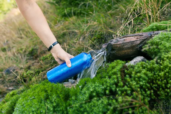 Жінка бере воду з весни — стокове фото