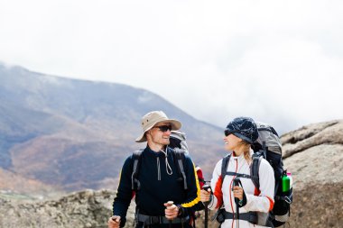 Man and woman hiking in mountains clipart