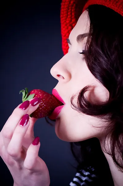 Piękna dziewczyna w czerwony beret jeść truskawki. — Zdjęcie stockowe