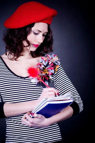 Französische Studentin in roter Baskenmütze mit Notizbüchern — Stockfoto