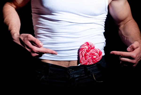 Modet muskulös man med röd lollipop — Stockfoto