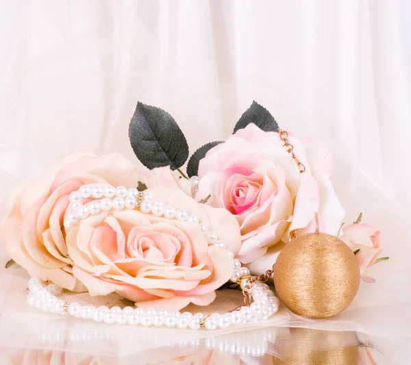 Прекрасная роза невесты и золотая свеча с бусами на белом фоне — стоковое фото