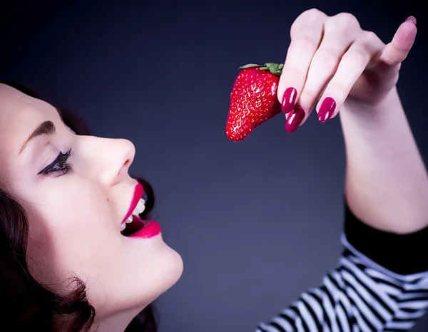 Schöne Mädchen in roter Baskenmütze Erdbeere essen. — Stockfoto