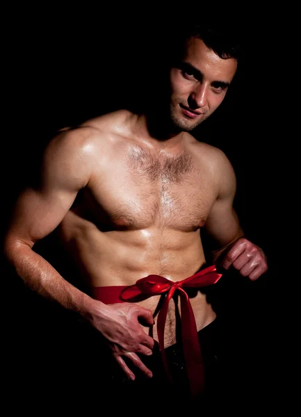 赤の弓とファッションのポーズで筋肉の男 — ストック写真