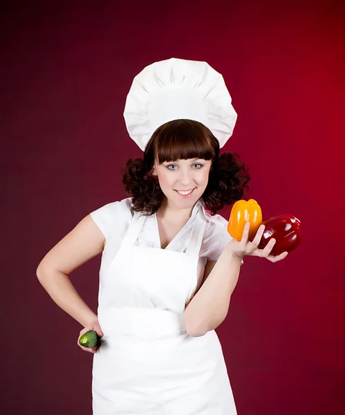 Sorridente donna cuoca felice tiene pepe — Foto Stock
