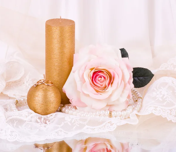 Романтический натюрморт с белой свечой и розами — стоковое фото