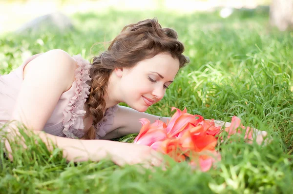 Beautiful woman with red spring tulips in a garden — Stock Photo, Image