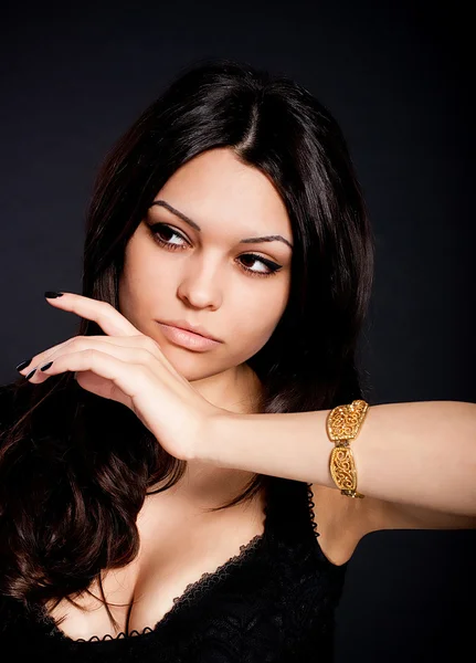Portrait of beautiful young woman with golden jewelry — Stock Photo, Image