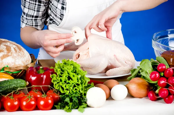 Femme cuisinière tient une poule brute — Photo