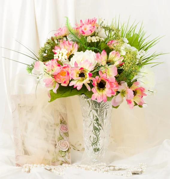 Bellissimi fiori primaverili in un vaso di vetro e cornice su sfondo — Foto Stock