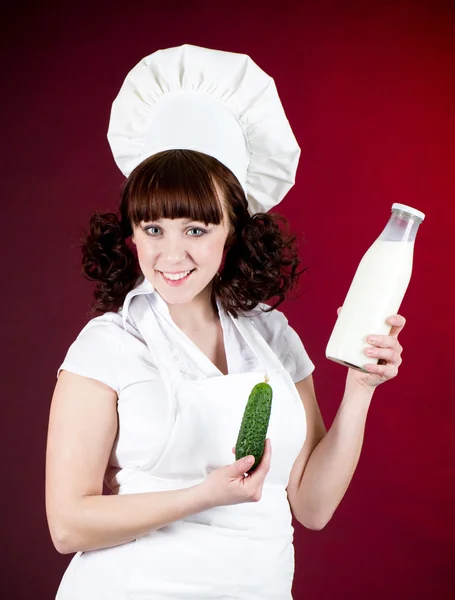 Sorridente donna cuoca felice con latte in bottiglia — Foto Stock