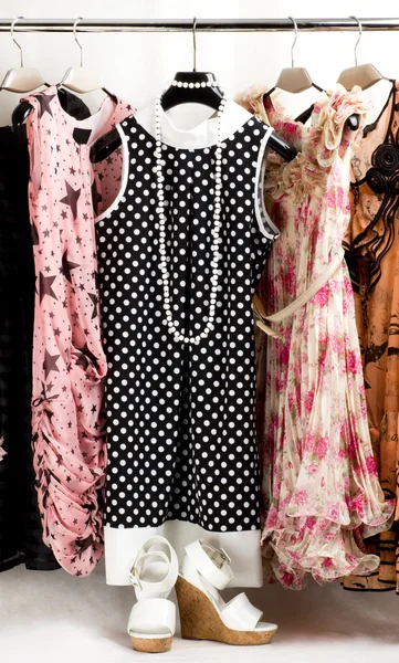 Moderiktiga kläder på pinnar i en kappa-rum — Stockfoto