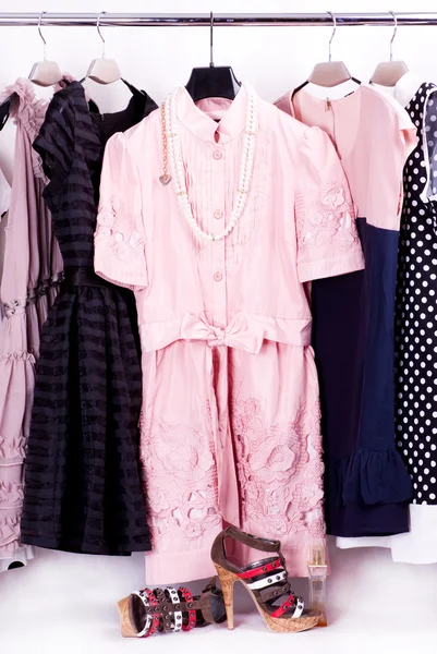 Roupa na moda em estacas em um quarto de manto — Fotografia de Stock