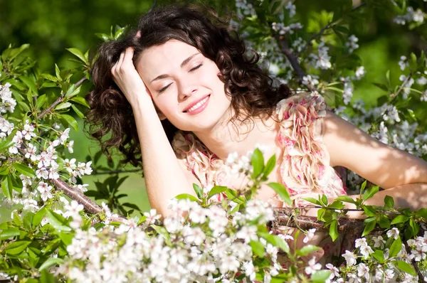 Beautiful woman in spring flowers — Stock Photo, Image