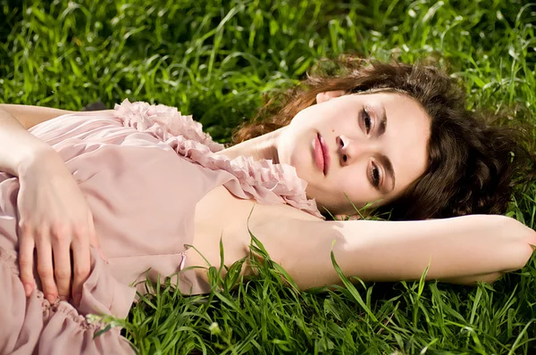Красива жінка на весняно-зеленій траві — стокове фото