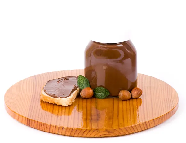 Chocolate spread container with a buttered toast and nuts — Stock Photo, Image