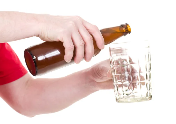 Ruka s lahví piva hnědé izolovaných na bílém — Stock fotografie
