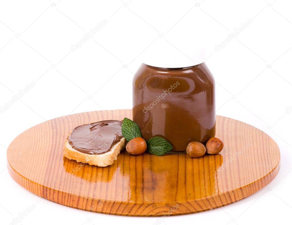 Chocolate spread container with a buttered toast and nuts