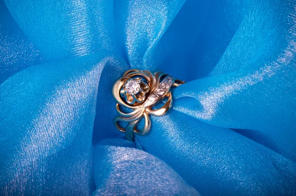 Biżuteria złoty pierścień na niebieskim tle — Zdjęcie stockowe