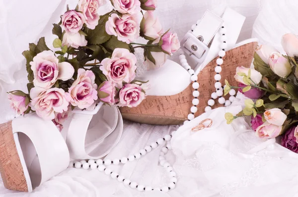 Винтажные кружева с цветами, обувью и обручальными кольцами на белом фоне . — стоковое фото
