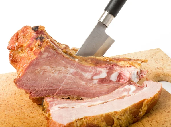 Smaczne mięso wędzone z pomieszczenia i nóż na białym tle — Zdjęcie stockowe