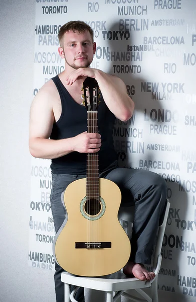 Junger Mann mit Gitarre auf dunklem Hintergrund — Stockfoto