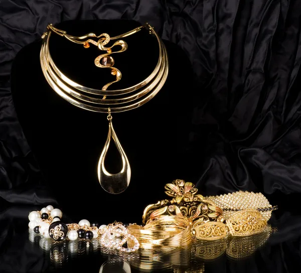 Zlaté šperky na černém pozadí — Stock fotografie