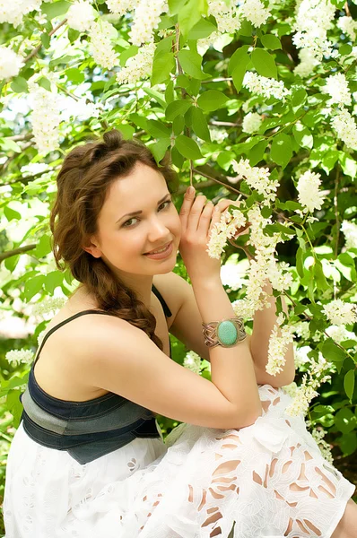 Beautiful woman in spring white flowers — Stock Photo, Image