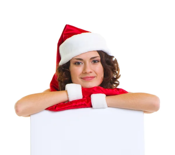 Vrouw in santa claus kleren leunend op een leeg bord — Stockfoto