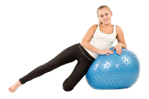 Mujer joven en el gimnasio con una bola azul —  Fotos de Stock