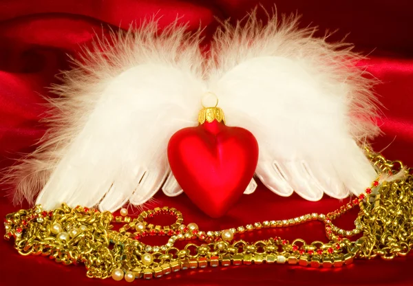 Valentine srdce s křídly na červeném pozadí — Stock fotografie