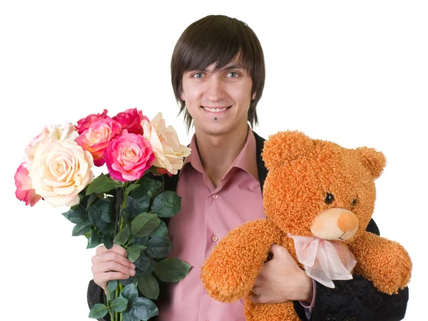 Giovane uomo con fiori e orsacchiotto — Foto Stock