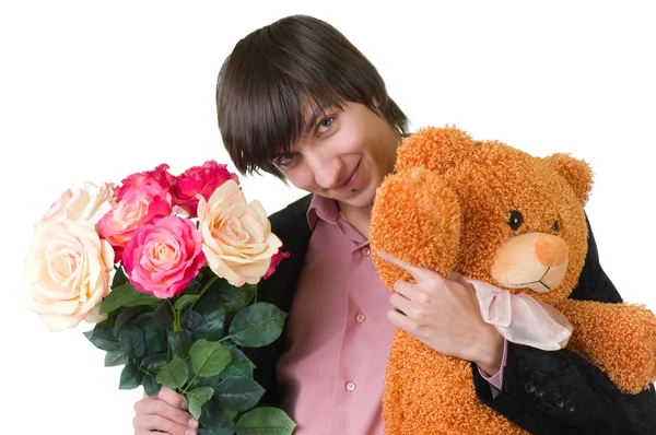 Young man with flowers and teddy bear — Stock Photo, Image