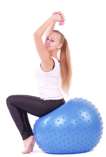 Mujer joven en el gimnasio con una bola azul — Foto de Stock