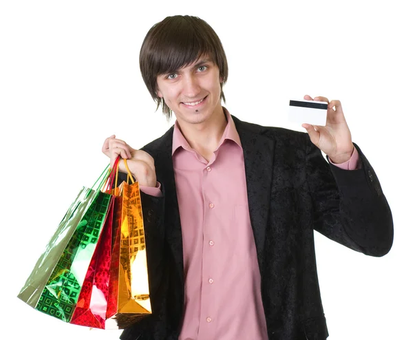 Jovem com cartão de crédito e sacos de compras — Fotografia de Stock