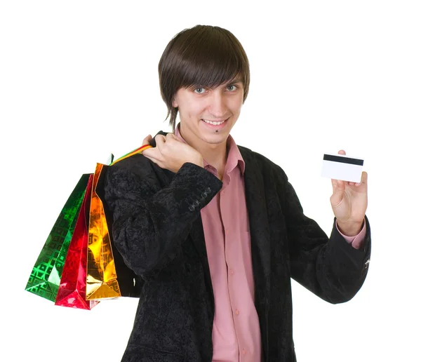 Jovem com cartão de crédito e sacos de compras — Fotografia de Stock