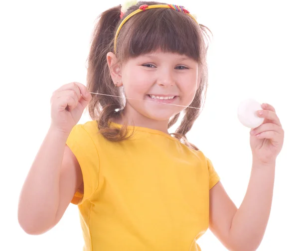 Güzel küçük bir kız dişlerini diş ipi — Stok fotoğraf