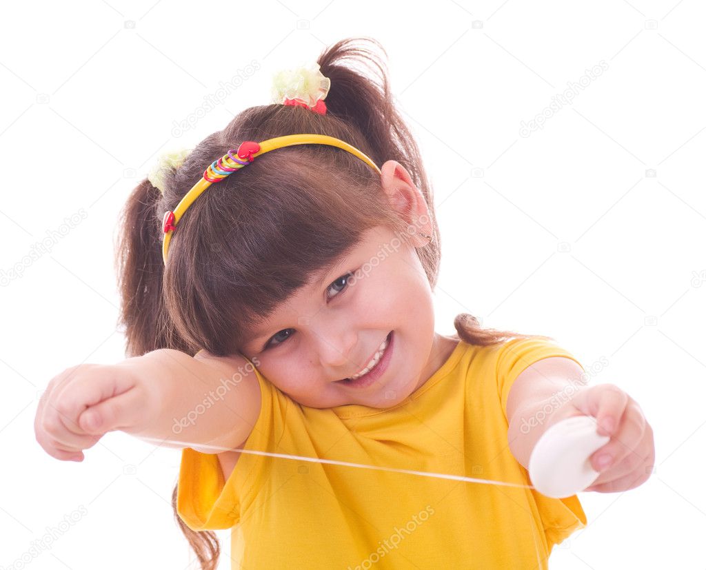 Beautiful little girl flossing her teeth