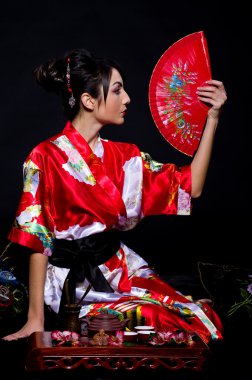 Woman in Asian costume with red Asian fan clipart