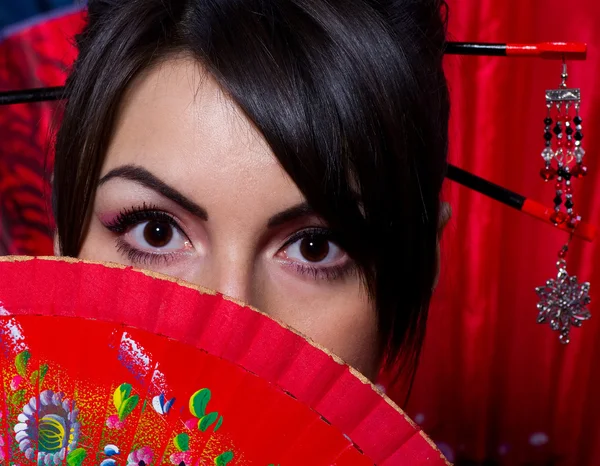 Beautiful young woman with red Asian fan — Stock Photo, Image