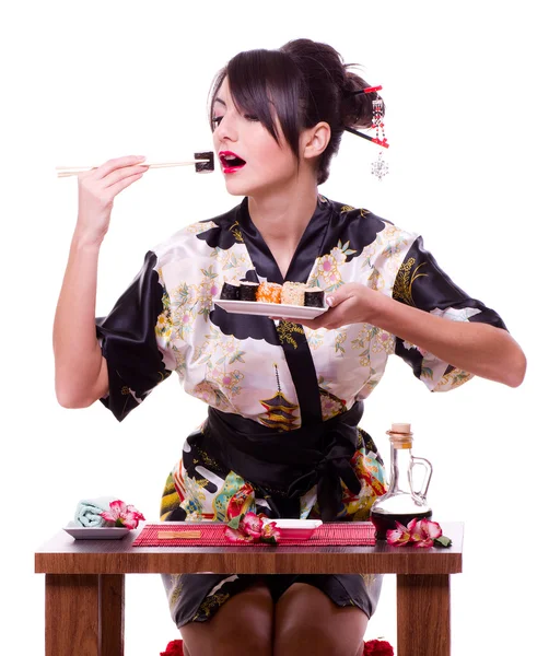 Mulher em quimono japonês com pauzinhos e rolo de sushi — Fotografia de Stock