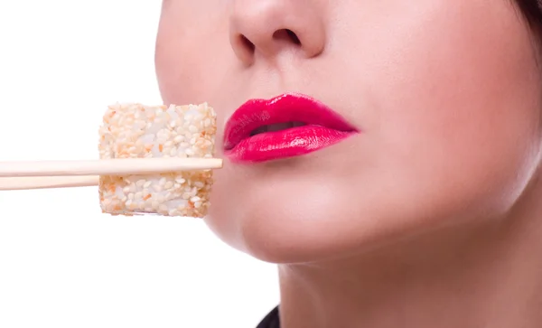 Женщина с палочками для еды и суши-рулетом — стоковое фото