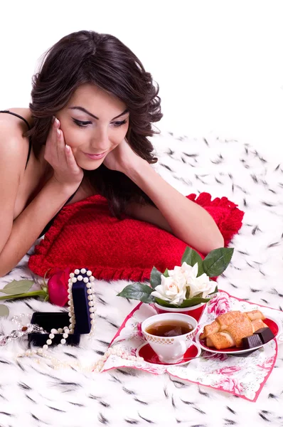 深色头发的女人在床上与礼物 — 图库照片