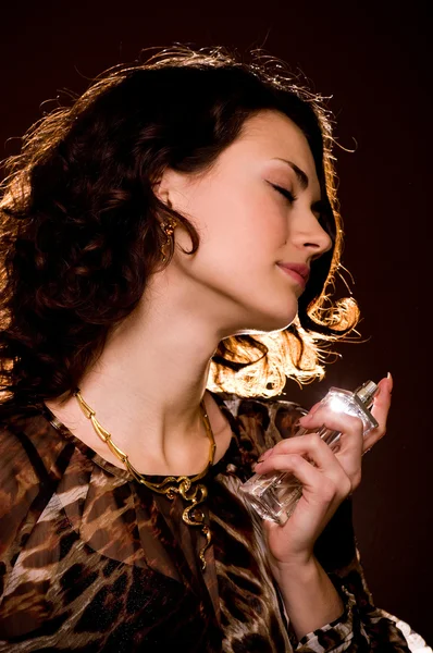 Portrait of beautiful young woman with perfume bottle — Stock Photo, Image