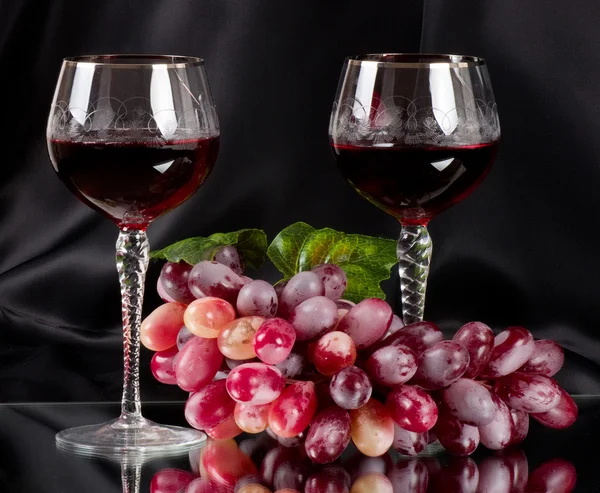 Červené víno ve skle s hroznovým vínem — Stock fotografie