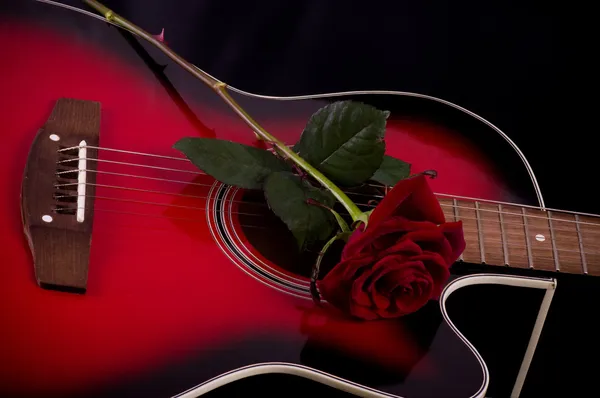 Schöne rote Gitarre mit roten Rosen — Stockfoto