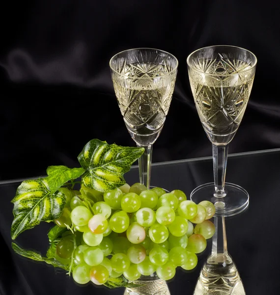 Bílé víno ve skle s hroznovým vínem — Stock fotografie
